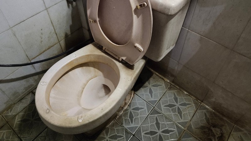 Dirty toilet bowl with hard water stains buildup
